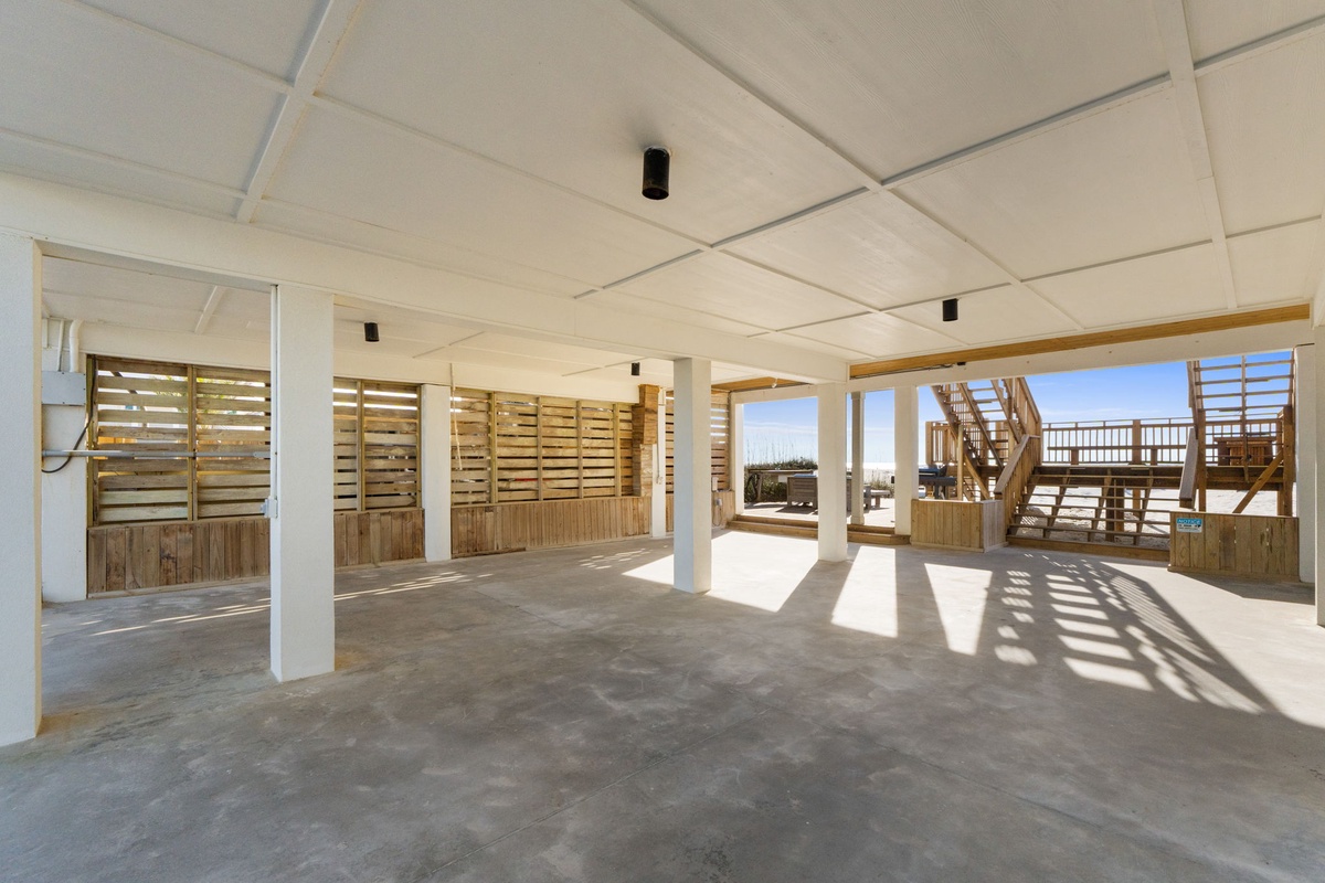 Spacious covered area with polished concrete floors offers flexible indoor-outdoor living beneath your vacation home.