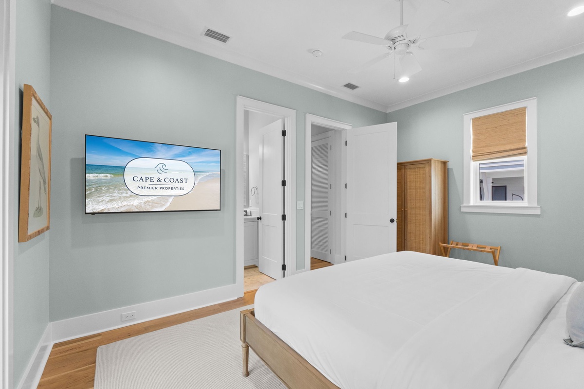 Unwind in this serene bedroom with calming coastal hues and crisp white linens. Your private wardrobe and modern entertainment setup create a peaceful retreat after beachside adventures.