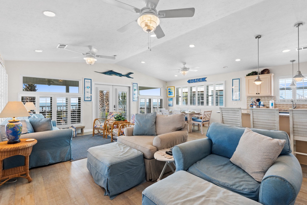 Unwind in your coastal haven with plush seating, ocean breezes from ceiling fans, and beach-themed touches throughout this bright, airy living space.