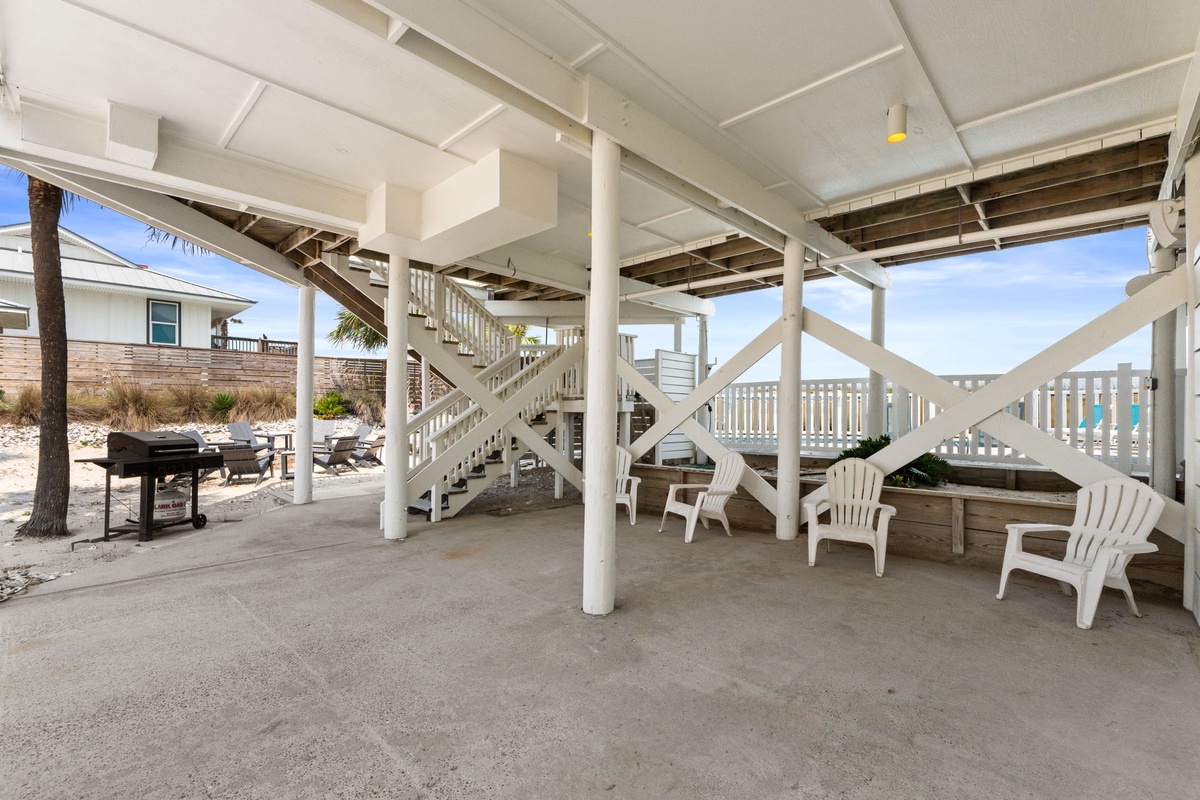 Steps away from the sand, your covered ground-level space offers shaded seating, a grill, and beach loungers just beyond—perfect for unwinding after sun-soaked days.
