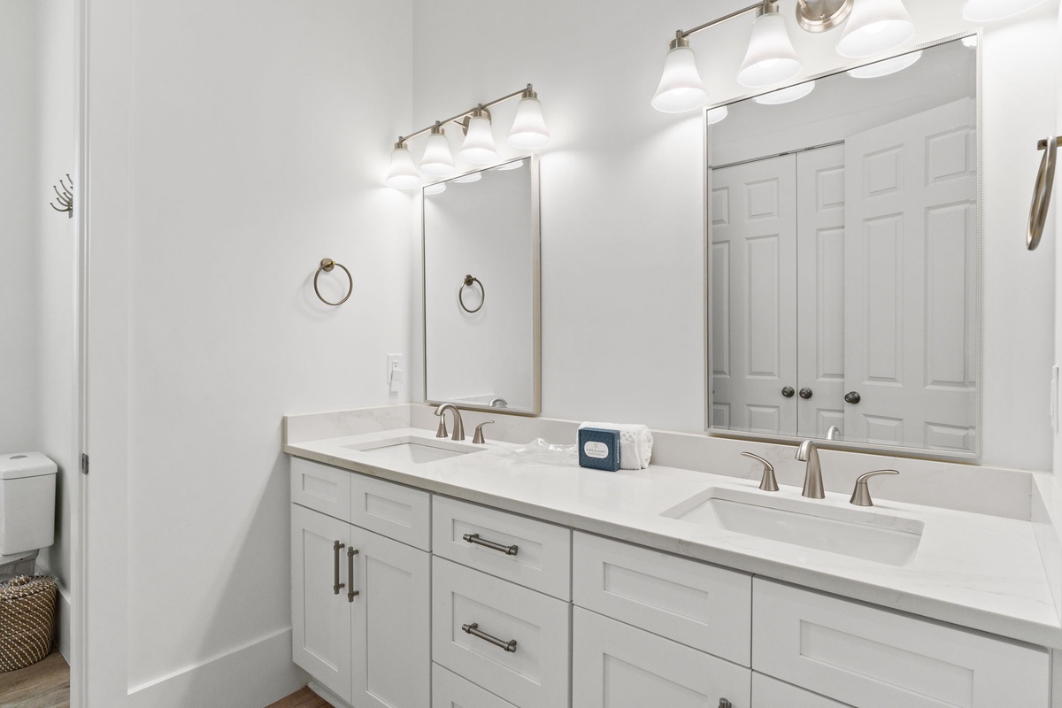 Freshen up in your spacious dual-vanity bathroom with elegant marble countertops and bright lighting for your morning routine.