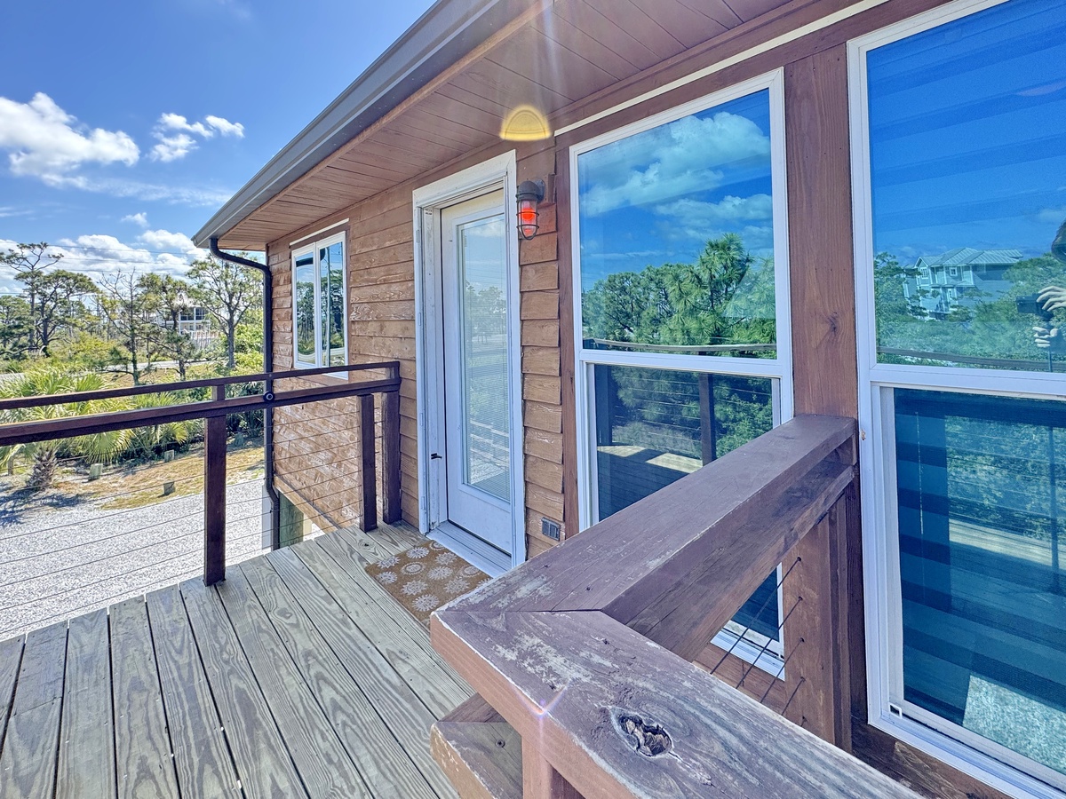 Spacious wooden deck with scenic tree views and comfortable outdoor seating area perfect for morning coffee or evening relaxation.