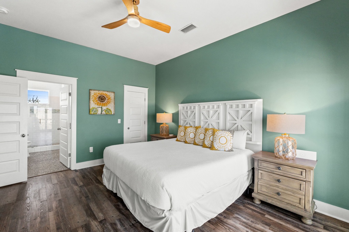 Drift off to peaceful sleep in your calming sage-green bedroom, featuring a cozy king bed and warm wood floors beneath your feet.