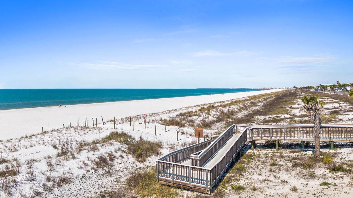 Pristine white sand beach stretches along turquoise waters with elevated boardwalk providing scenic access to this beautiful Gulf Coast shoreline.