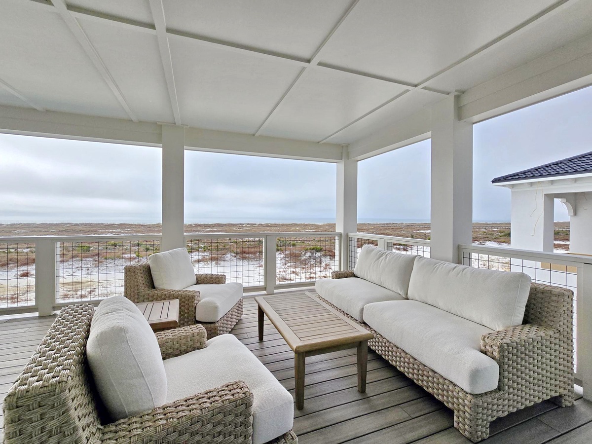 Relax in your private covered terrace with panoramic views across unspoiled landscapes, where comfortable seating invites peaceful moments.