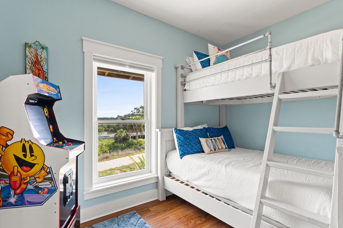 Relax in this bright, cheerful bunk room overlooking peaceful water views. Classic arcade fun and cozy beds make it your perfect retreat after exploring nearby adventures.