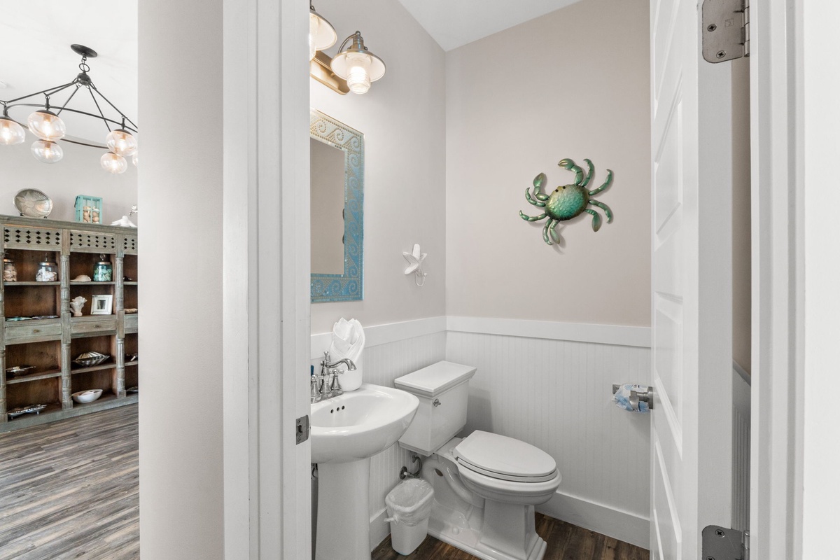 Your private powder room features coastal charm with a charming crab accent and crisp white finishes for convenient refreshing.