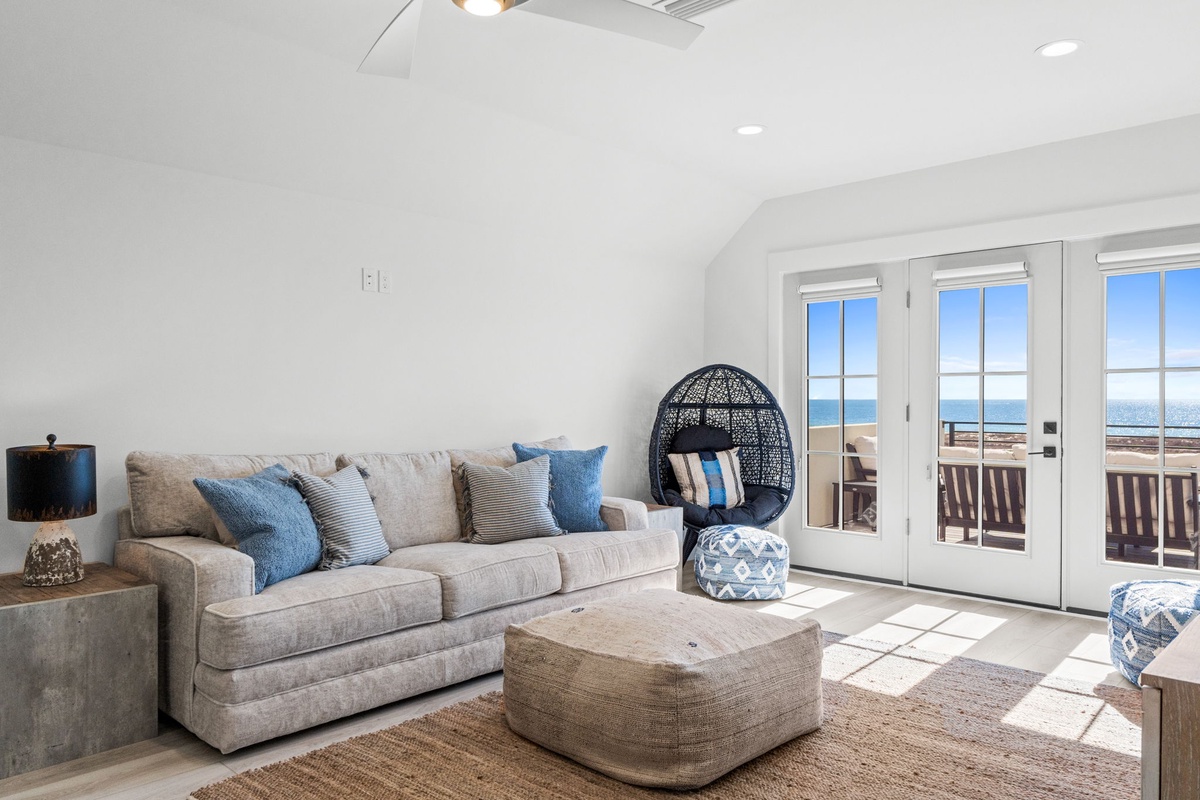 Unwind in your bright, modern living space with plush seating and stunning ocean views through French doors to your private balcony.