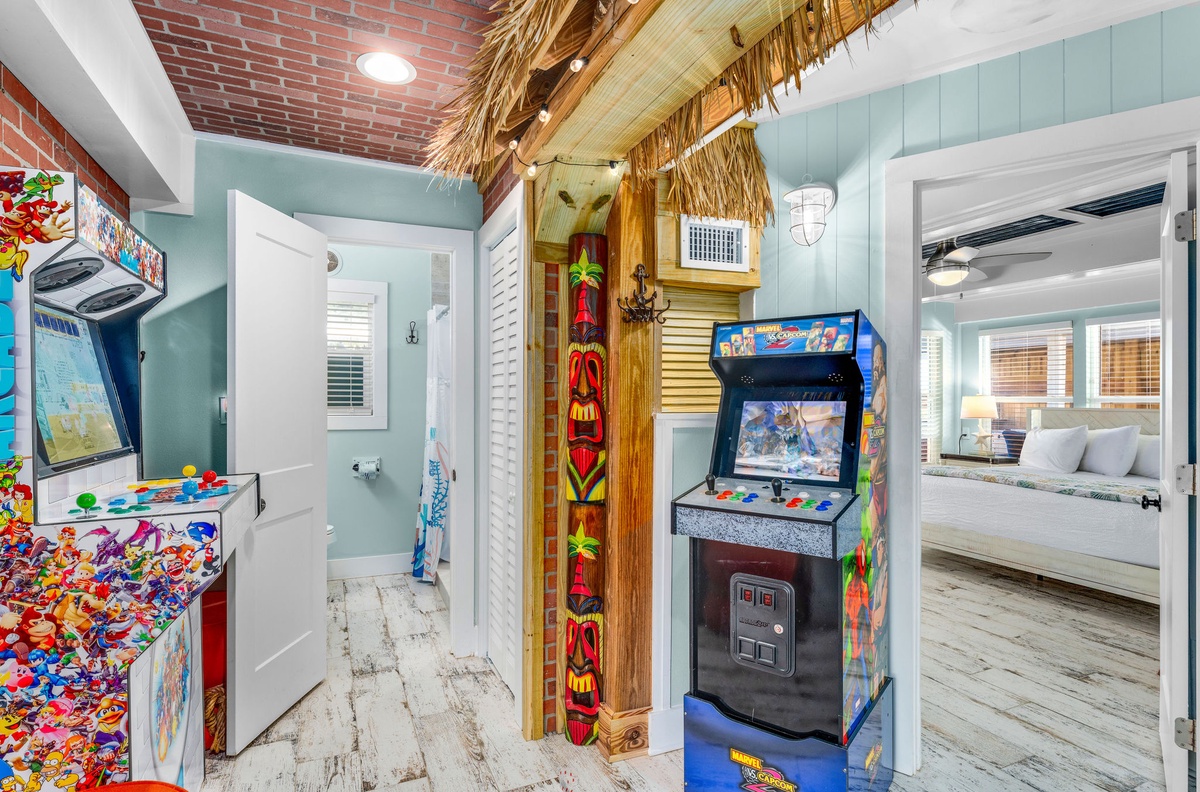 Step into your tropical game room where colorful arcade games await under a thatched tiki hut—perfect for family fun time indoors.
