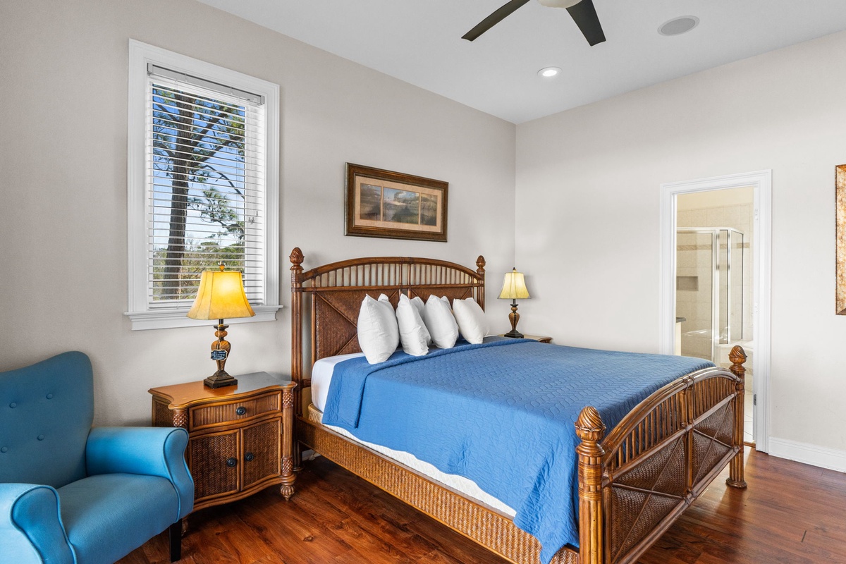 Drift off in this peaceful bedroom featuring a comfortable bed, warm lighting, and cheerful blue accents that create your perfect retreat.