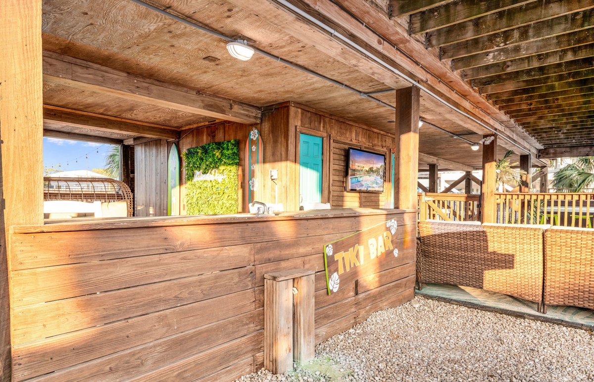Unwind at your tropical tiki bar where island vibes meet modern comfort under rustic wooden beams and warm lighting.