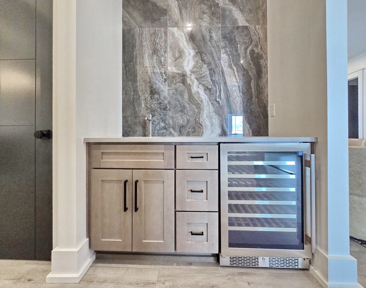 Your elegant wet bar features stunning marble backsplash and built-in wine fridge for perfect entertaining moments.