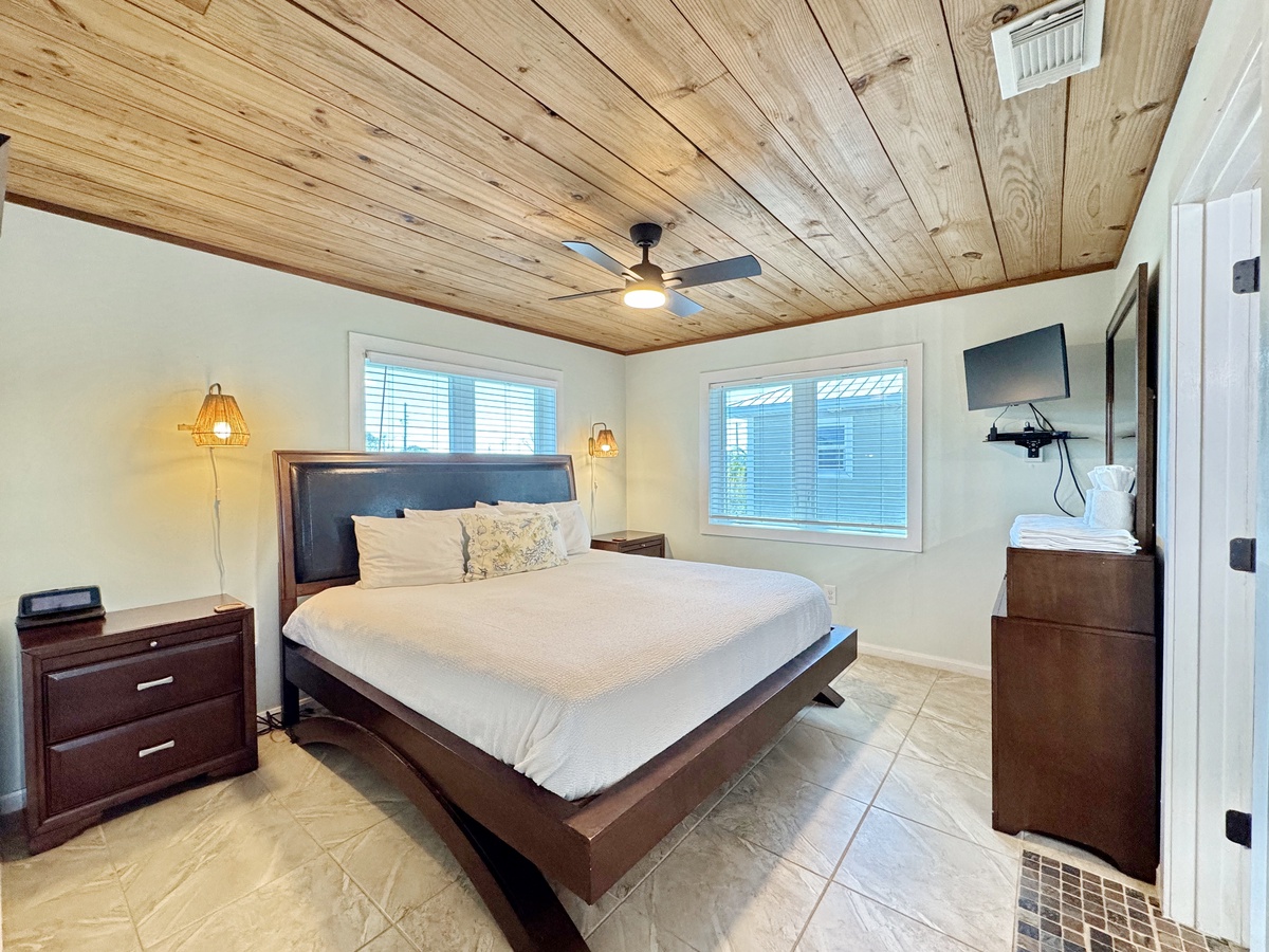 Your peaceful bedroom retreat features rustic wood ceilings, stylish pendant lighting, and comfortable furnishings for the perfect night's rest.