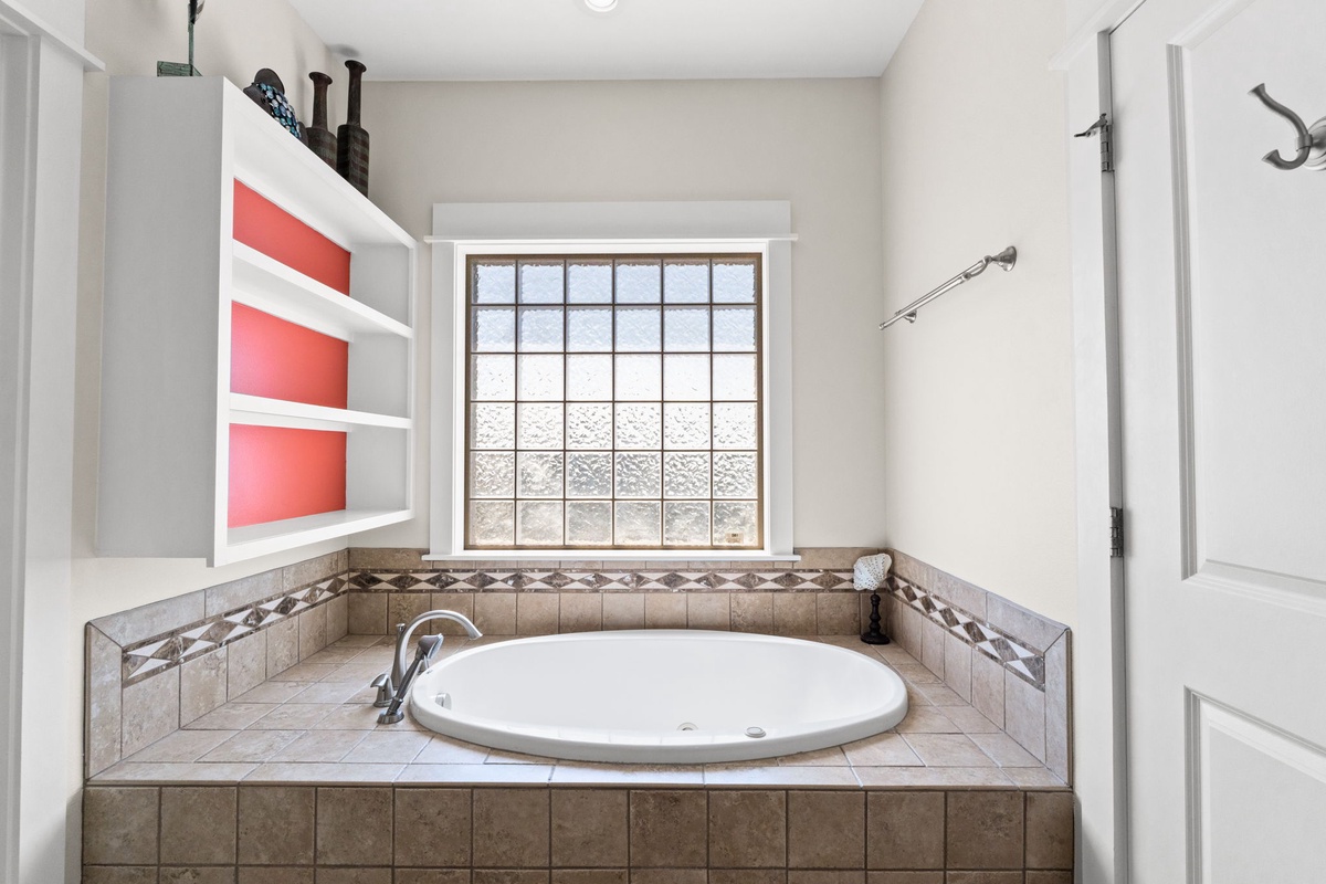 Sink into your private spa sanctuary with this elegant soaking tub, surrounded by beautiful tile work and natural light.