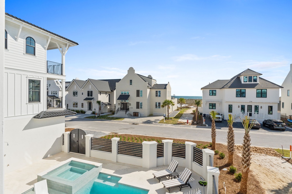 Coastal development featuring luxury vacation homes with modern architecture and pristine landscaping under brilliant blue skies.