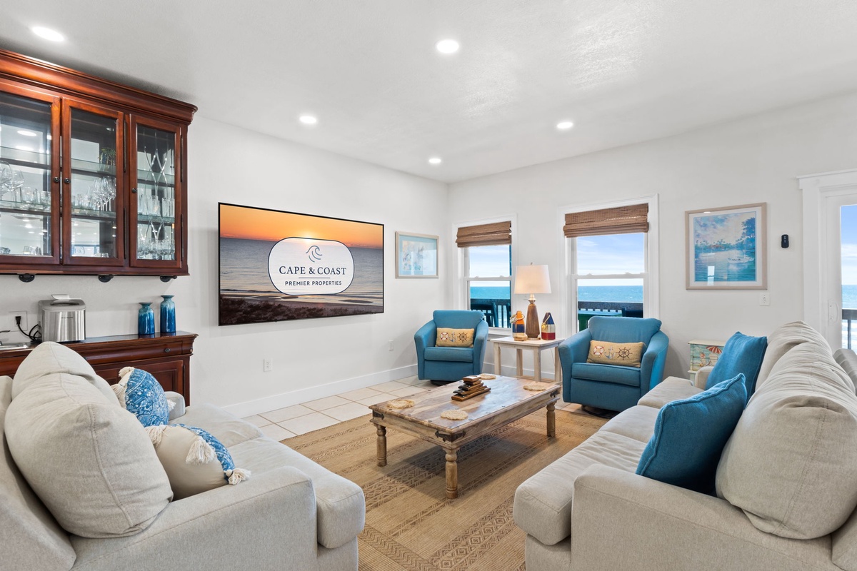 Sink into plush seating and soak up stunning ocean views through your windows. This bright living room invites you to unwind with beachy décor and coastal charm all around.
