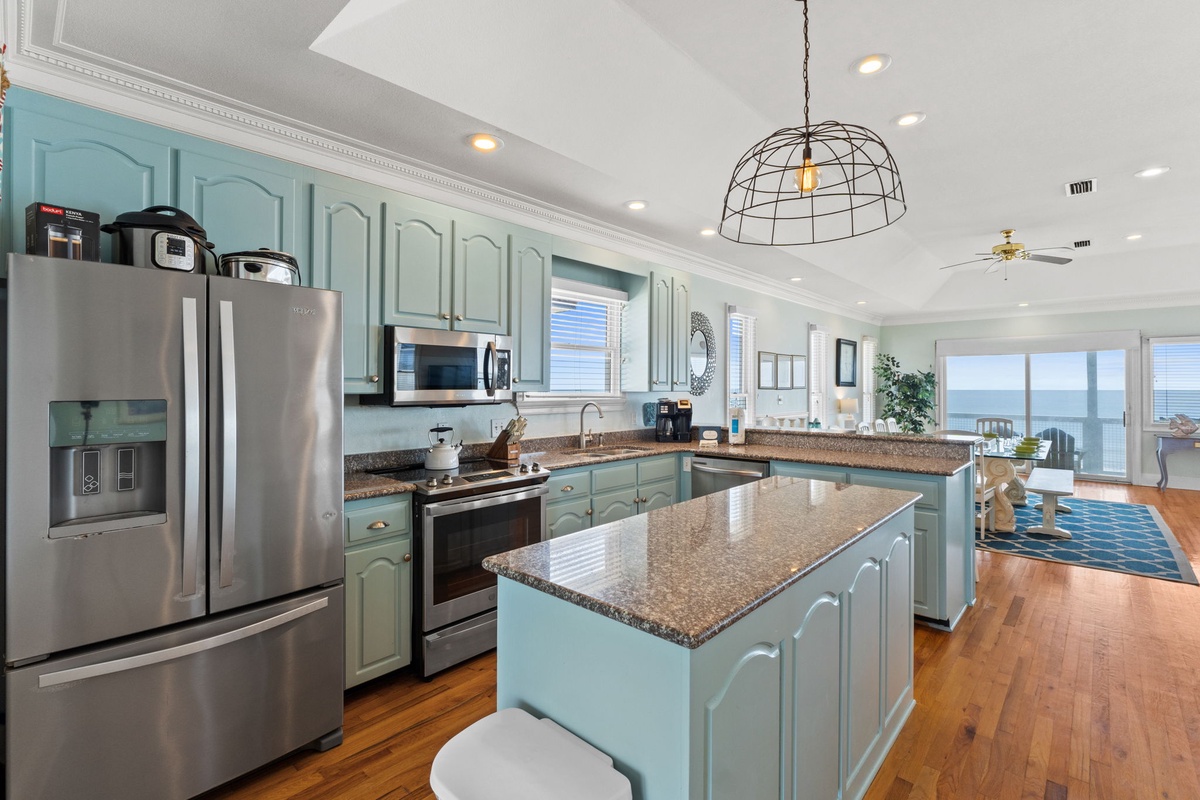 Your spacious kitchen features mint cabinetry, granite counters, and stainless appliances, perfect for preparing meals while enjoying ocean views.