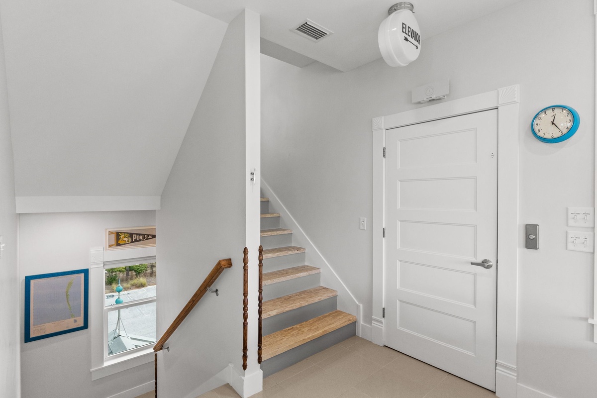 Bright, airy stairwell with charming nautical touches leads you between floors in your coastal retreat.