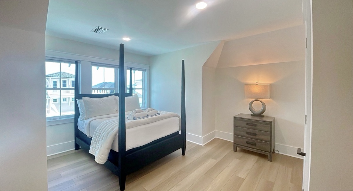 Step into your serene bedroom sanctuary, where a stunning four-poster bed invites restful nights and a beautifully lit alcove adds elegant charm to your coastal getaway.