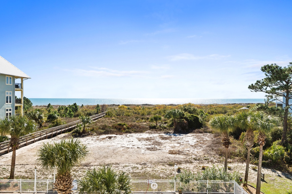 Stunning coastal setting with direct beach access via boardwalk, surrounded by natural dunes and tropical palms.