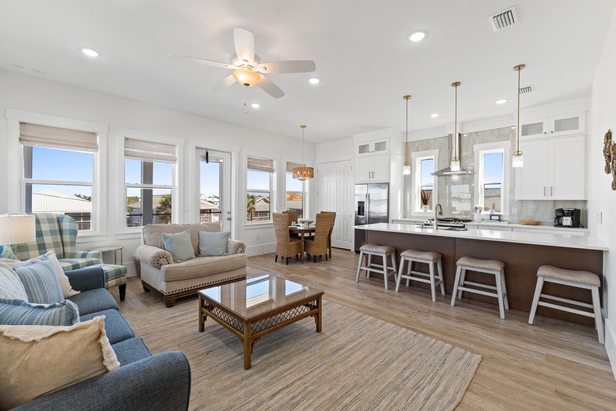 Relax in your bright, open living space where coastal blues meet modern comfort. The kitchen island awaits your morning coffee rituals.