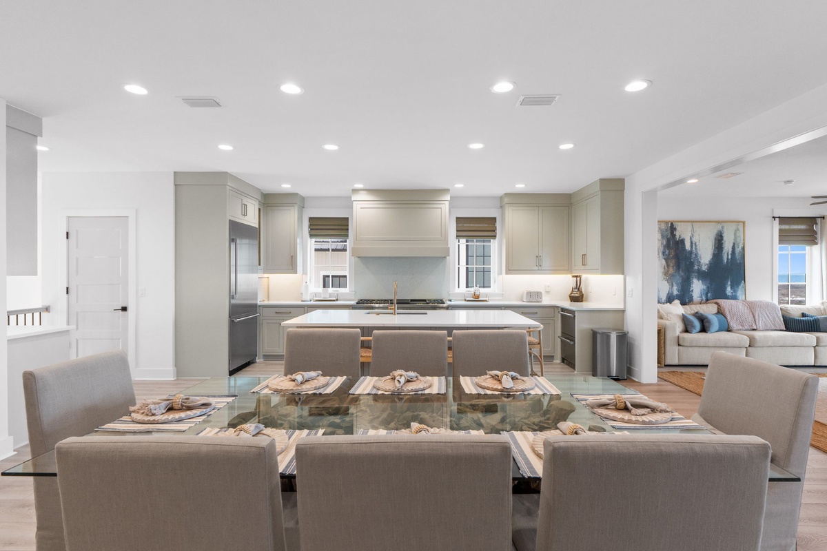 Gather around your elegant glass dining table while the chef-quality kitchen awaits your culinary adventures in this sophisticated open-concept space.