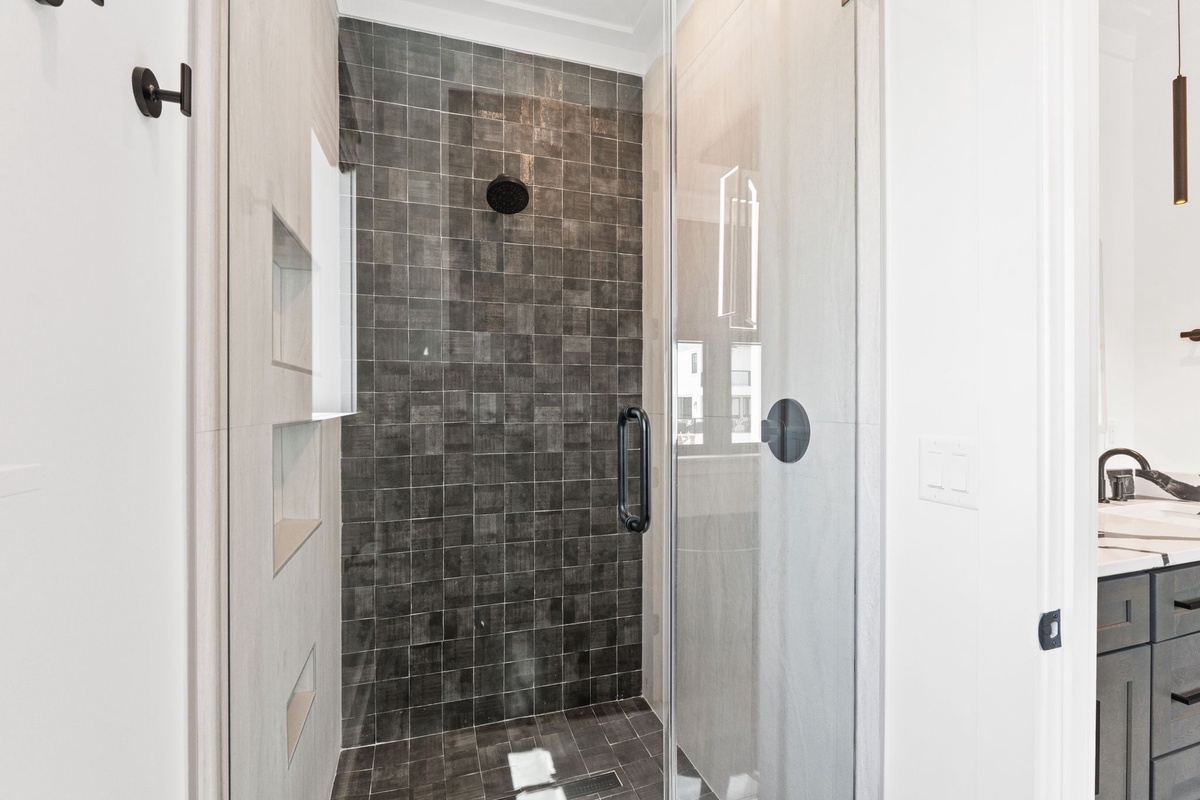 Step into your private rainfall shower with gorgeous mosaic tile, offering a spa-like retreat after a day exploring the area.