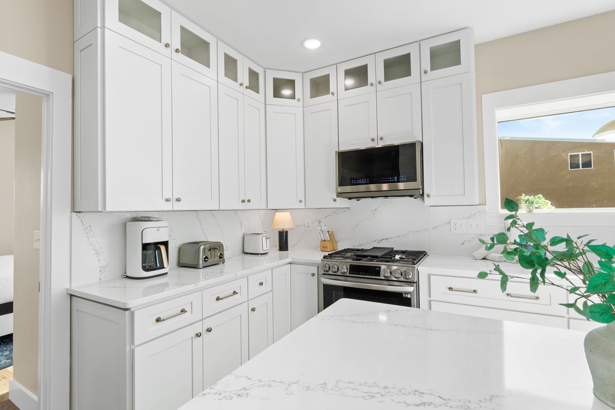 Your dream kitchen awaits with pristine white cabinets, marble countertops, and premium appliances ready for culinary adventures.