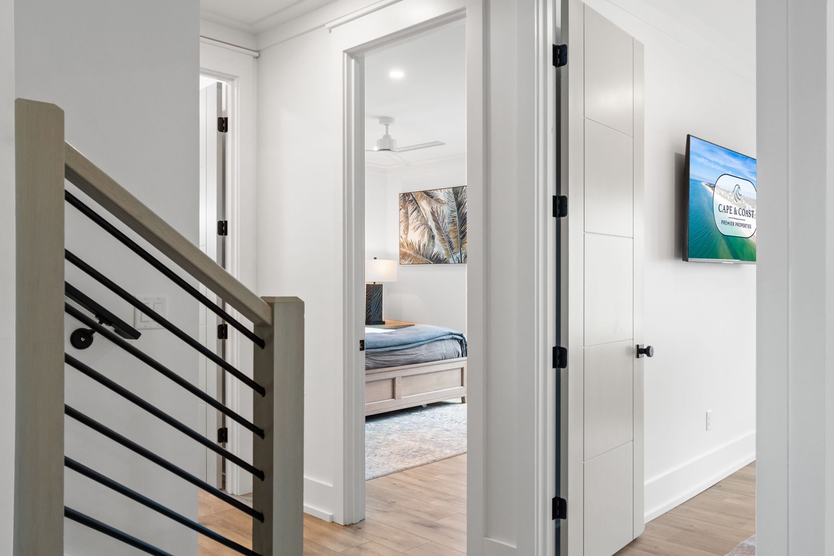Your bright hallway leads to peaceful bedrooms, each thoughtfully decorated with coastal artwork to help you unwind after adventurous days.