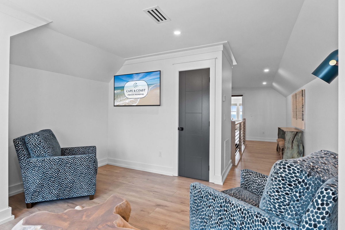 Settle into your private lounge upstairs, where coastal-inspired seating and warm wood floors create the perfect spot to relax, read, or plan your next adventure by the shore.