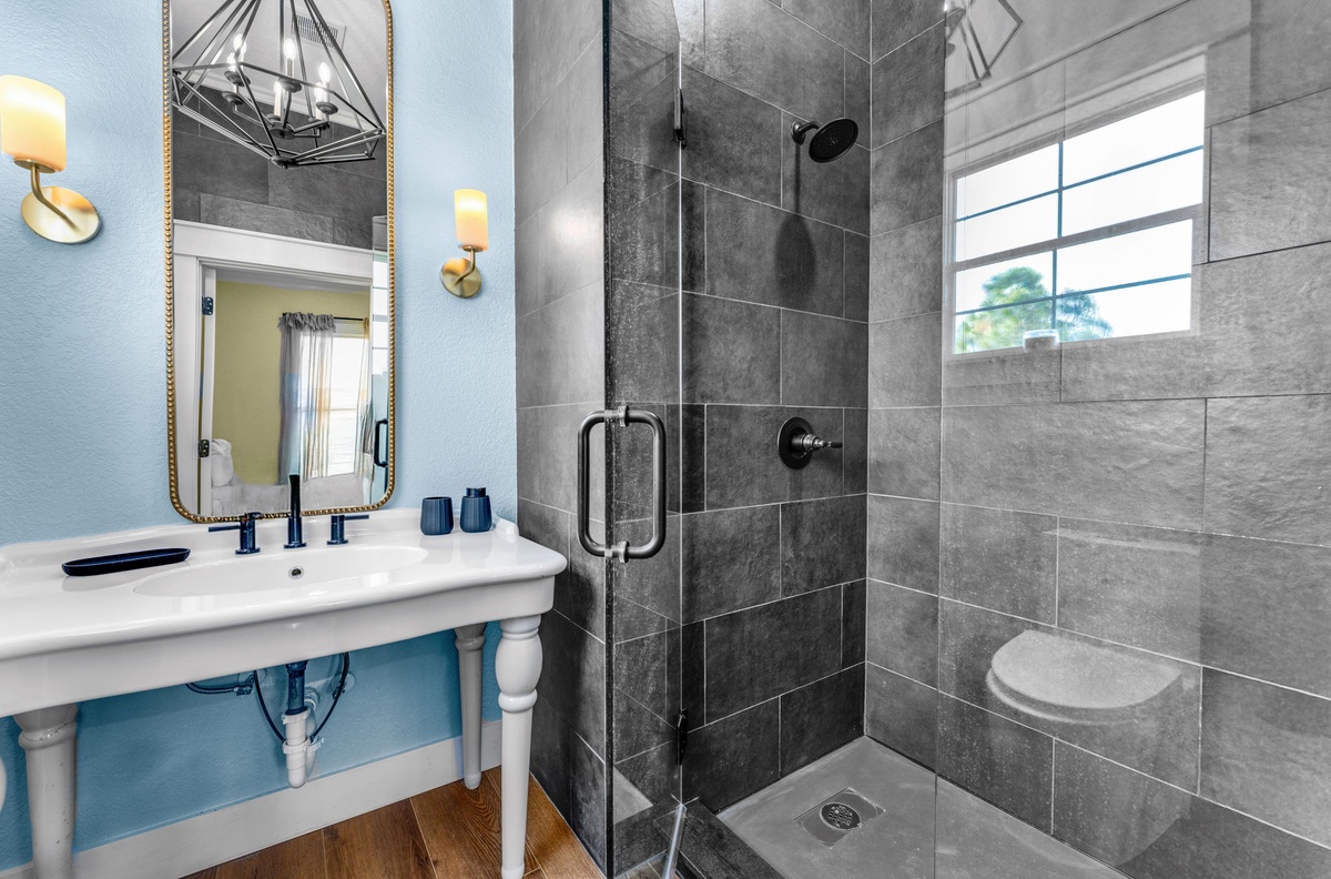 Refresh in your stylish bathroom featuring a spacious glass shower, elegant fixtures, and soothing blue accents for a spa-like experience.