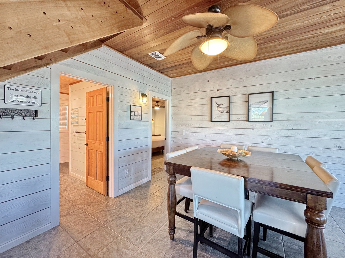 Gather around your rustic dining table beneath exposed wooden beams and a gentle ceiling fan for memorable meals together.