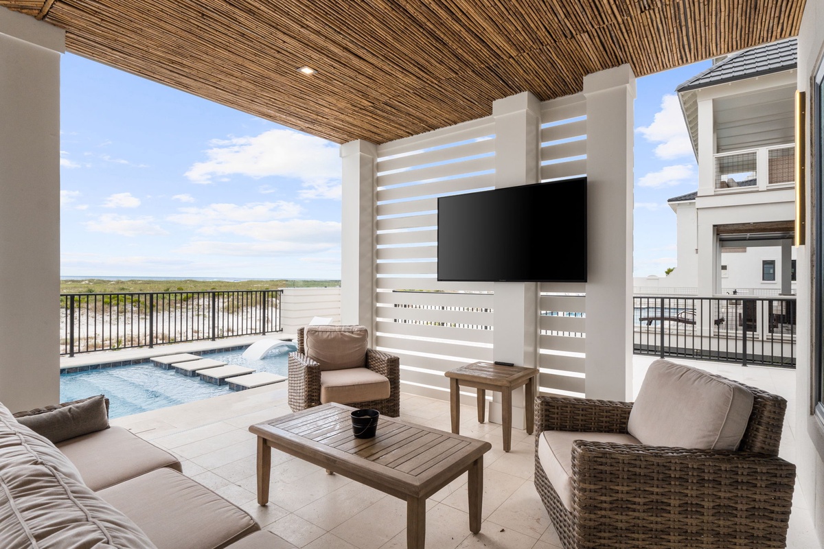 Spacious lakefront terrace overlooking calm waters with comfortable wicker seating, your private hot tub, and an outdoor TV for the ultimate relaxation experience.