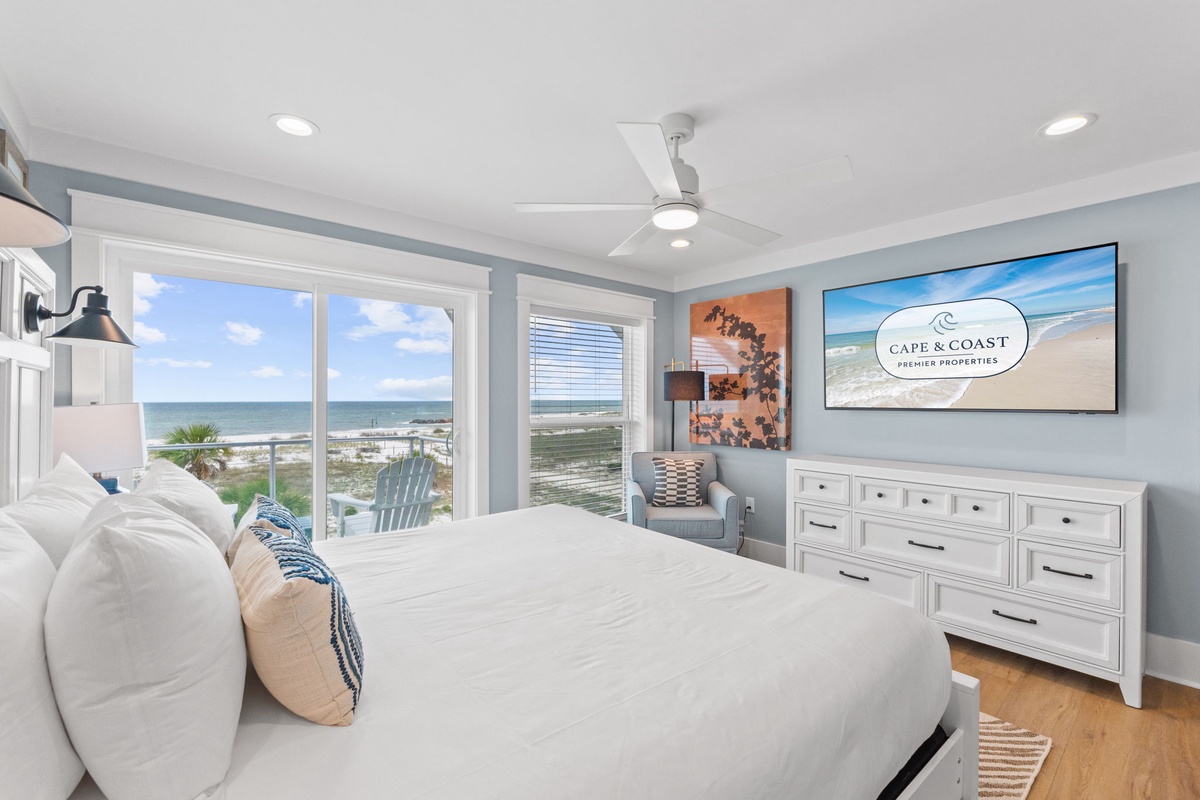 Wake up to stunning ocean views framed by your private windows and balcony access. Your bright coastal bedroom features soft linens, ample storage, and gentle breezes from the ceiling fan above.