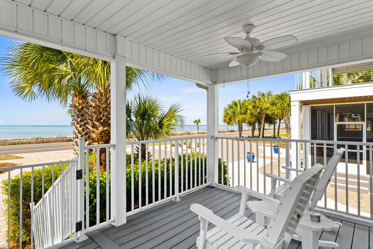 Relax on your private covered balcony with comfortable seating while enjoying stunning beach views and gentle ocean breezes through swaying palm trees.