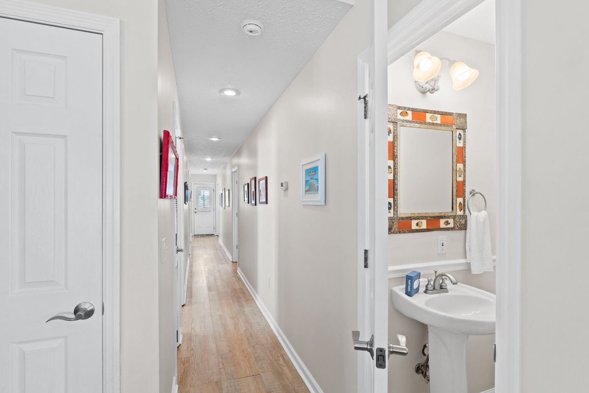 You'll love the bright hallway connecting your space, with a convenient half-bath featuring colorful tilework perfect for freshening up.