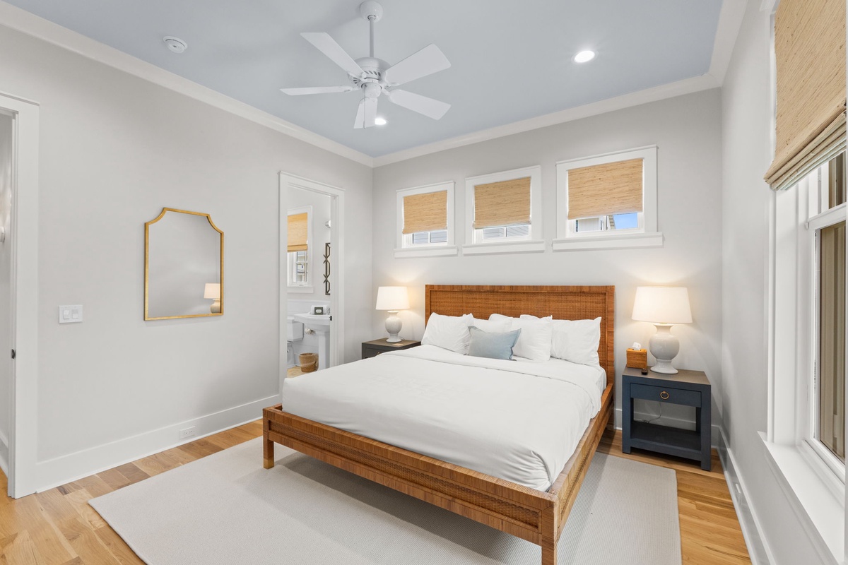 Drift off to sleep in your serene bedroom, where crisp linens, warm wood tones, and soft lamplight create a peaceful retreat after a day of coastal adventures.