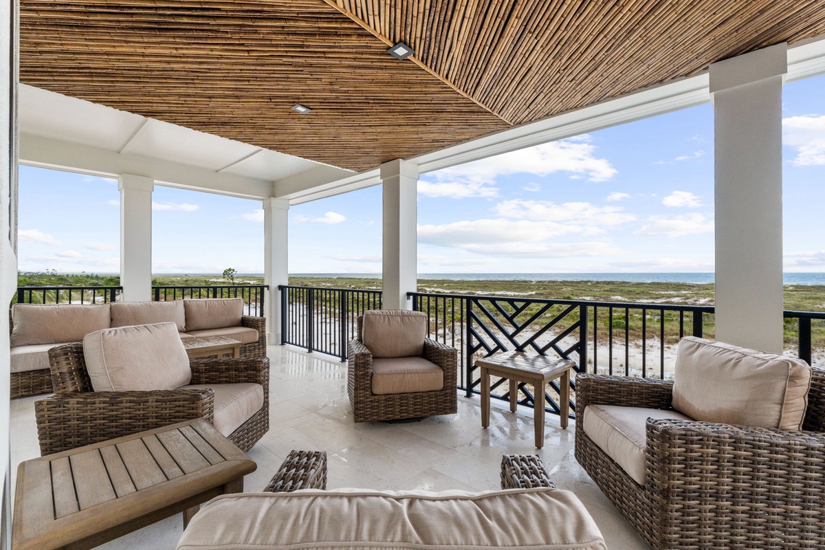 Settle into plush wicker seating beneath a stunning slatted wooden ceiling and soak in sweeping views of the coastline and natural landscape stretching endlessly before you.