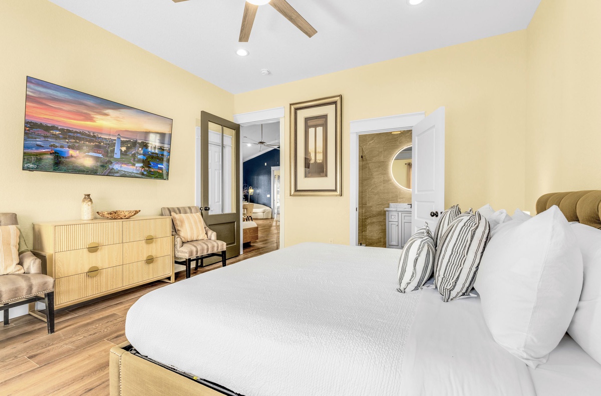 Sink into luxurious comfort in this elegant bedroom featuring crisp linens, exposed beams, and an ensuite bathroom for your perfect getaway.