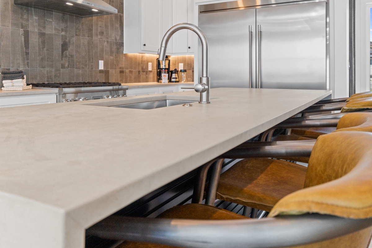 Your gourmet kitchen features pristine quartz counters, professional appliances, and stylish seating where you'll love preparing meals together.