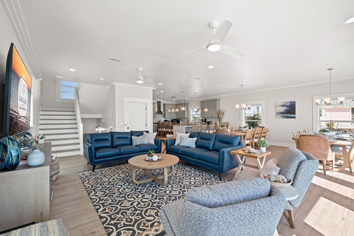 Relax in your spacious open-plan living area, where plush blue sofas and modern furnishings create the perfect atmosphere for unwinding after your adventures.