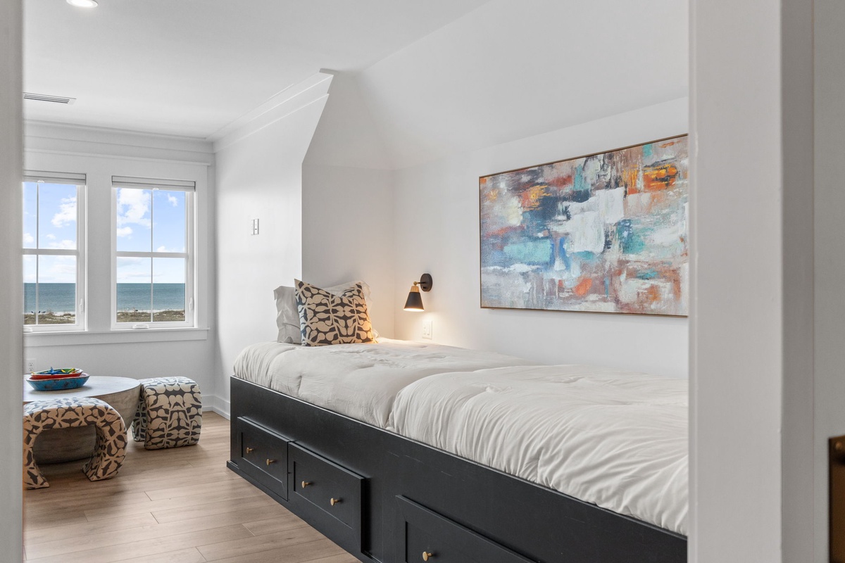 Your cozy alcove bedroom features built-in storage and stunning ocean views through bright windows.