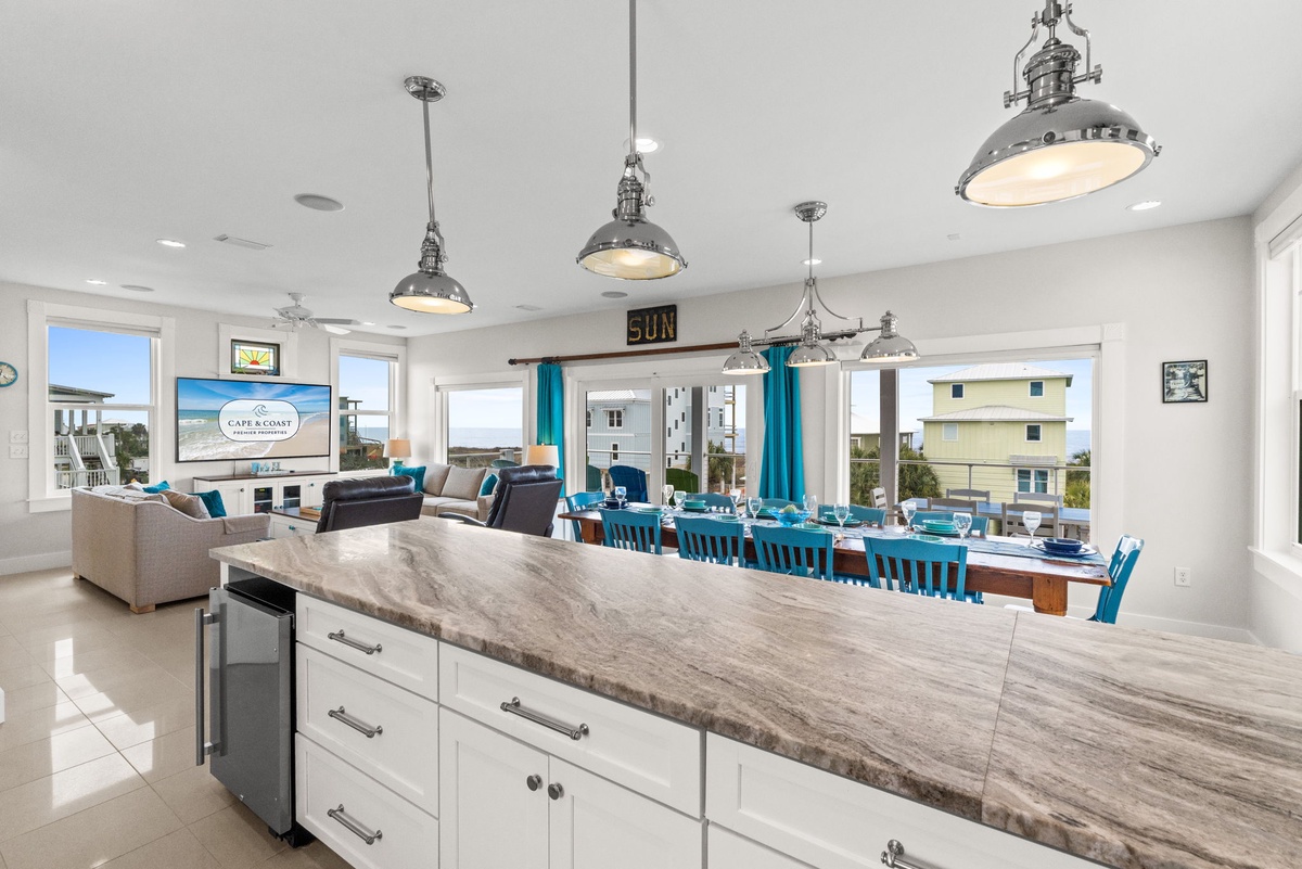 Your open-concept living space features industrial pendant lights, marble counters, and turquoise accents throughout.