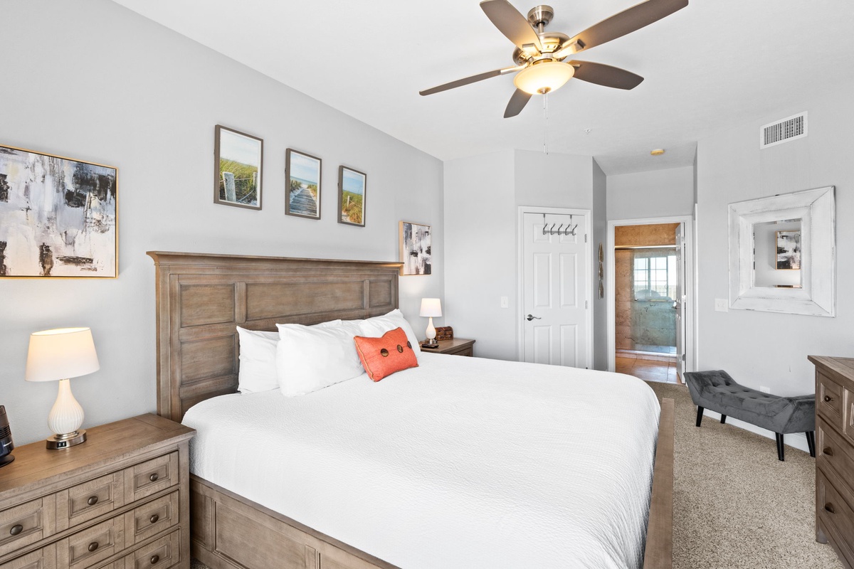 Unwind in your spacious bedroom with crisp white linens, warm wood furnishings, and a cozy reading chair.