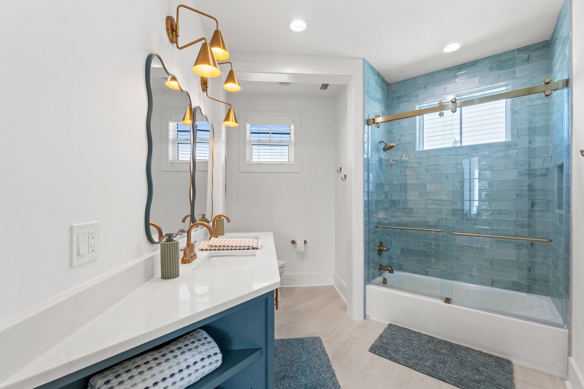 Unwind in your spa-like retreat with stunning blue tile, rainfall shower, and modern fixtures creating the perfect sanctuary.