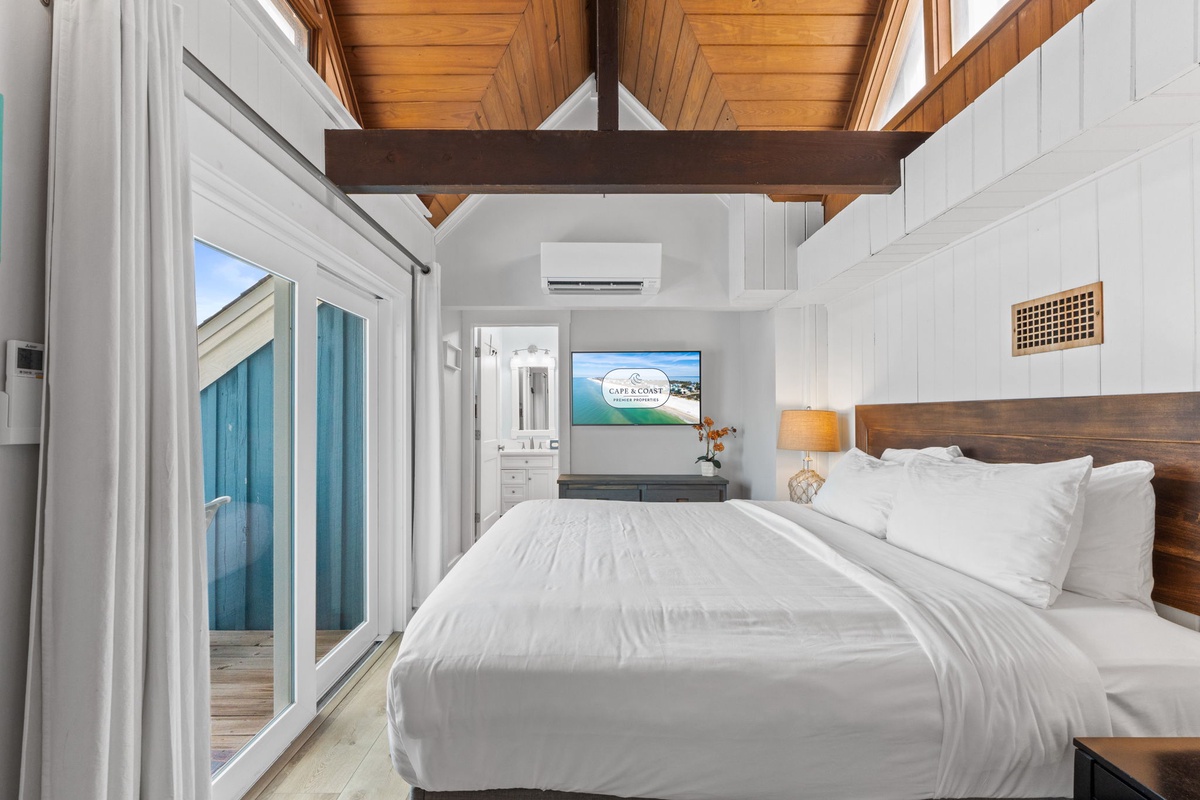 Drift off under soaring wood ceilings in your serene bedroom, where crisp linens and coastal breezes welcome you home after a day of island adventures.
