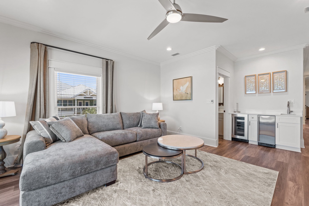 Unwind in this inviting living space with plush seating, modern touches, and a wet bar perfect for your evening relaxation. Soft natural light and a sleek ceiling fan keep you comfortable year-round.