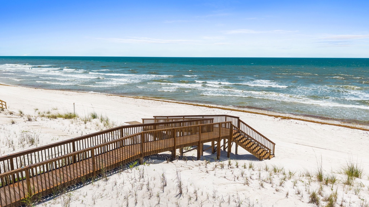 Wooden boardwalk leads from the property across pristine white sand dunes to the sparkling turquoise waters and gentle waves of this stunning beachfront location.