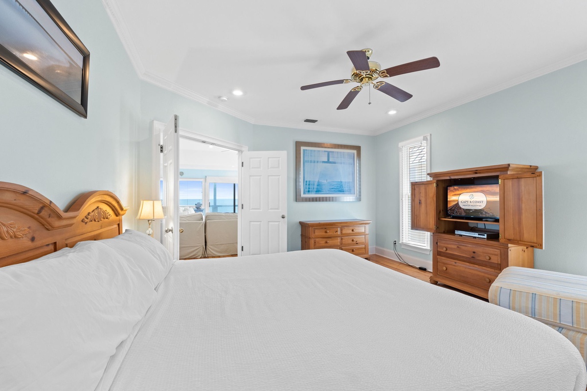Wake up in your serene bedroom where soft coastal colors and warm wood furnishings create the perfect retreat, with ocean views beckoning beyond.
