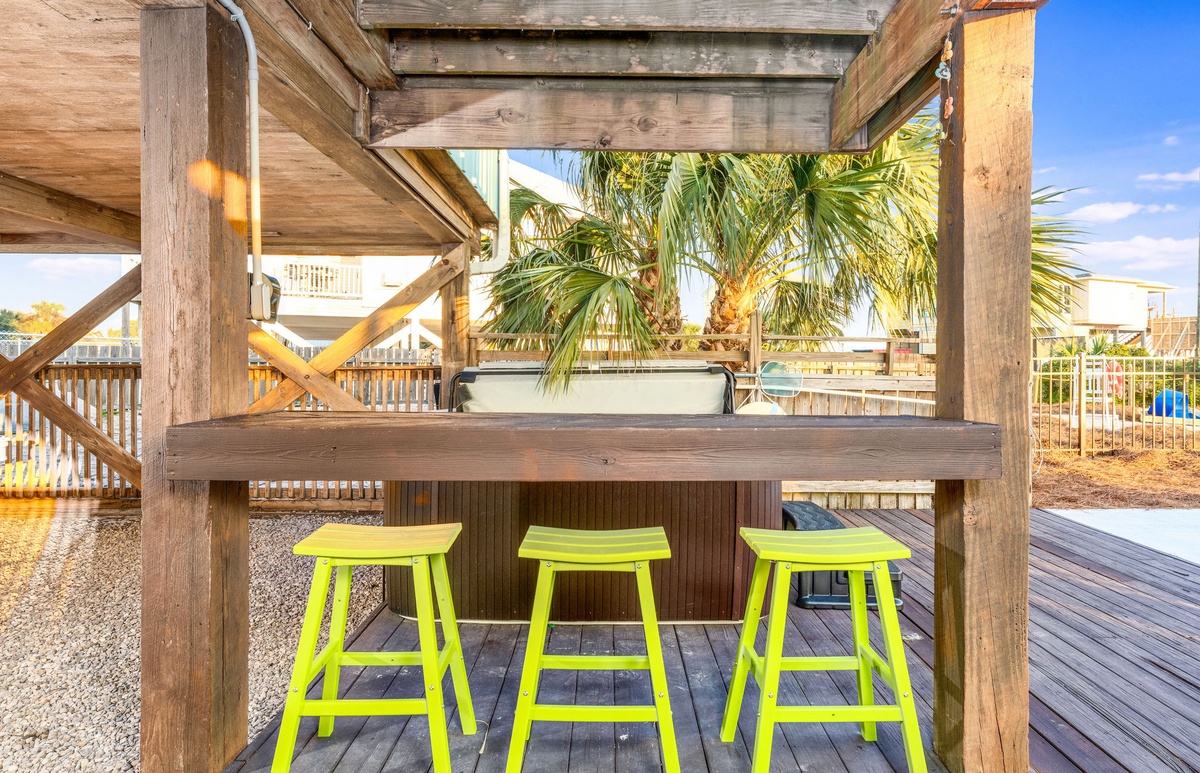Gather around this tropical tiki bar where bright green stools invite you to sip drinks under swaying palm trees.